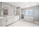 Luxurious bathroom features a double vanity, soaking tub, and walk-in shower with modern tile at 12024 Girasole Ave, Las Vegas, NV 89138