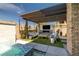 Inviting outdoor space featuring a covered patio with a fireplace, TV, comfortable seating, and a hot tub for relaxation at 12024 Girasole Ave, Las Vegas, NV 89138