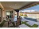 Outdoor patio with a table and chairs set, adjacent to the waterfall and pool at 12024 Girasole Ave, Las Vegas, NV 89138