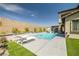 Backyard with a sparkling pool, lounge chairs, and a covered patio, perfect for outdoor relaxation and entertainment at 12024 Girasole Ave, Las Vegas, NV 89138