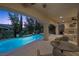 A covered patio overlooks a pool with a spa, offering a serene outdoor living space for relaxation and entertainment at 12125 Edgehurst Ct, Las Vegas, NV 89138