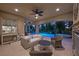 Covered patio with a view of the pool, spa, and lush landscaping, offering an ideal space for outdoor entertaining and relaxation at 12125 Edgehurst Ct, Las Vegas, NV 89138
