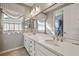 Bright bathroom featuring dual sinks, a decorative mirror, and elegant fixtures at 12125 Edgehurst Ct, Las Vegas, NV 89138