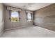 Empty bedroom featuring a wood accent wall, two windows, and neutral tones at 12125 Edgehurst Ct, Las Vegas, NV 89138