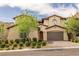 Beautiful home exterior with a paver driveway, two-car garage, and lush landscaping at 12125 Edgehurst Ct, Las Vegas, NV 89138