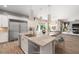 Virtually staged kitchen offers a large island, stainless appliances, and views of the dining area and pool at 12125 Edgehurst Ct, Las Vegas, NV 89138