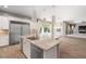 The chef's kitchen offers a large island, stainless appliances, a tile backsplash and access to the pool at 12125 Edgehurst Ct, Las Vegas, NV 89138