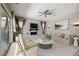 Bright, virtually staged living room features a modern fireplace, ceiling fan, and sliding glass doors at 12125 Edgehurst Ct, Las Vegas, NV 89138