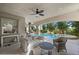 Covered patio with comfortable seating, a ceiling fan, and views of the pool and lush backyard landscaping at 12125 Edgehurst Ct, Las Vegas, NV 89138