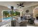 Outdoor patio with a stone fireplace, comfortable seating, an outdoor heater, and a pool with mature trees at 12125 Edgehurst Ct, Las Vegas, NV 89138