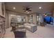Covered patio with stone fireplace, ceiling fans, and seamless access to the home's interior, perfect for relaxing and entertaining at 12125 Edgehurst Ct, Las Vegas, NV 89138