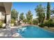 Inviting pool area featuring a sparkling pool, lounge chairs, and lush landscaping, perfect for relaxation and outdoor enjoyment at 12125 Edgehurst Ct, Las Vegas, NV 89138