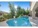 Landscaped backyard with a sparkling pool, spa, mature trees and partial shade on a sunny day at 12125 Edgehurst Ct, Las Vegas, NV 89138