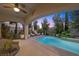 Outdoor patio featuring a sparkling pool and lush trees creating a serene oasis for relaxing and entertaining in style at 12125 Edgehurst Ct, Las Vegas, NV 89138