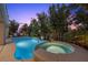 Beautiful backyard pool with a built-in spa, surrounded by lush greenery and a stone tile border, ideal for relaxation and entertainment at 12125 Edgehurst Ct, Las Vegas, NV 89138