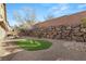 Private backyard featuring artificial grass, a rock wall, and gravel landscaping at 1265 Vietti St, Henderson, NV 89012