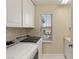 Functional laundry room with washer, dryer, window, cabinets and a utility sink at 1265 Vietti St, Henderson, NV 89012