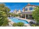 Backyard with a sparkling pool, relaxing spa, covered patio, and lush landscaping providing a private oasis at 13 Cozy Glen Cir, Henderson, NV 89074