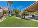 Expansive backyard with artificial grass, a playhouse, and covered patio adjacent to the sparkling swimming pool at 13 Cozy Glen Cir, Henderson, NV 89074