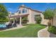 Backyard featuring artificial turf, a covered patio, and sparkling pool creating a private retreat for relaxation at 13 Cozy Glen Cir, Henderson, NV 89074