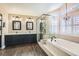 Bathroom features a dual sink vanity, soaking tub, glass enclosed shower and wood look floors at 13 Cozy Glen Cir, Henderson, NV 89074