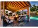 Comfortable covered patio with seating around a fire pit, perfect for outdoor living by the pool at 13 Cozy Glen Cir, Henderson, NV 89074