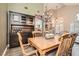 Elegant dining area with wood-look flooring, a chandelier, and a stylish hutch for storage and display at 13 Cozy Glen Cir, Henderson, NV 89074