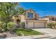 Charming two-story home with manicured lawn, mature trees, and a welcoming double-door entrance at 13 Cozy Glen Cir, Henderson, NV 89074