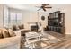 Bright living room with fireplace, large windows, and a comfortable sofa at 13 Cozy Glen Cir, Henderson, NV 89074
