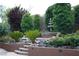 Landscaped backyard featuring a tiered garden, a decorative water fountain, mature trees, and a cozy seating area at 17 Chatmoss Rd, Henderson, NV 89052