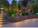 A beautiful outdoor space featuring garden accents, various plants, and soft lighting at 17 Chatmoss Rd, Henderson, NV 89052