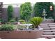 Beautiful backyard with multi-tiered landscaping, mature trees, colorful flowers, and a charming water fountain feature at 17 Chatmoss Rd, Henderson, NV 89052