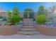 Lush backyard with a stone water fountain feature flanked by vibrant greenery and manicured landscaping at 17 Chatmoss Rd, Henderson, NV 89052
