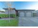 Charming home exterior with a two-car garage, manicured lawn, and well-maintained landscaping at 17 Chatmoss Rd, Henderson, NV 89052