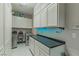 Well-equipped laundry room featuring sleek white cabinets, a dark countertop, and modern washer and dryer units at 17 Chatmoss Rd, Henderson, NV 89052