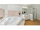 Bathroom featuring a large bathtub with tile surround, a glass shower, and bright lighting at 1707 Navarre Ln, Henderson, NV 89014
