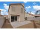 A two-story home has a sliding glass door leading to a concrete patio in the backyard at 1909 Falling Tree Ave, North Las Vegas, NV 89031