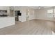 Open-concept living room with kitchen view, wood-look floors, and a cozy fireplace at 1909 Falling Tree Ave, North Las Vegas, NV 89031