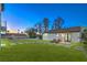 Expansive backyard with a manicured lawn, tiled stepping stones, and luxurious lounge chairs at 210 E Longacres Dr, Henderson, NV 89015