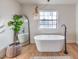 Bright bathroom featuring a modern soaking tub, plant decor, and decorative light fixture at 210 E Longacres Dr, Henderson, NV 89015