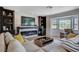 Cozy living area featuring a modern fireplace, built-in shelving, and a bay window at 210 E Longacres Dr, Henderson, NV 89015
