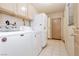 Functional laundry area equipped with modern washing machine and dryer units and utility sink at 2255 S Buffalo Dr, Las Vegas, NV 89117