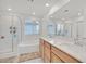 Well-lit bathroom featuring a tub-shower combo, dual sinks, and neutral decor at 2885 Timber Country Rd, North Las Vegas, NV 89086