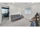 Clean bedroom featuring a comfortable grey futon, bright windows, and neutral carpeting at 2885 Timber Country Rd, North Las Vegas, NV 89086
