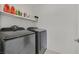 Well-equipped laundry room with modern washer and dryer and ample shelving for storage and convenience at 2885 Timber Country Rd, North Las Vegas, NV 89086