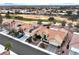 Stunning aerial view of houses with red tile roofs next to golf course with mountain and city views in the distance at 3004 Darby Falls Dr, Las Vegas, NV 89134