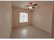 A spacious and light-filled bedroom with a modern ceiling fan, tiled floors, and a bright window dressed with horizontal blinds at 3004 Darby Falls Dr, Las Vegas, NV 89134
