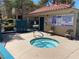 Community hot tub area with posted rules, chairs, and a gated entrance for residents at 311 Manti Pl # 311, Henderson, NV 89014