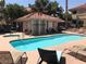 Community pool and hot tub with lounge chairs and a small cabana-style building nearby at 311 Manti Pl # 311, Henderson, NV 89014