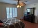Bedroom featuring a dark wood dresser, queen bed, ceiling fan, and large shuttered windows at 3125 N Buffalo Dr # 1080, Las Vegas, NV 89128
